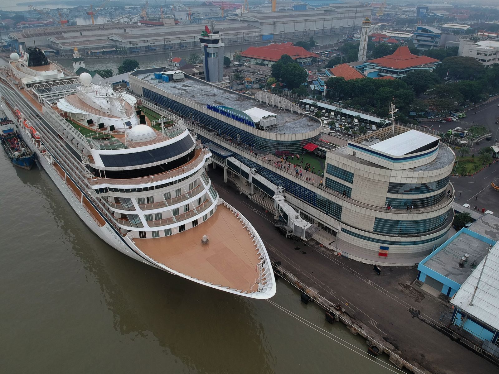 Aerial view of a cruise ship alongside a modern cruise terminal, ready for travellers who compare cruise prices