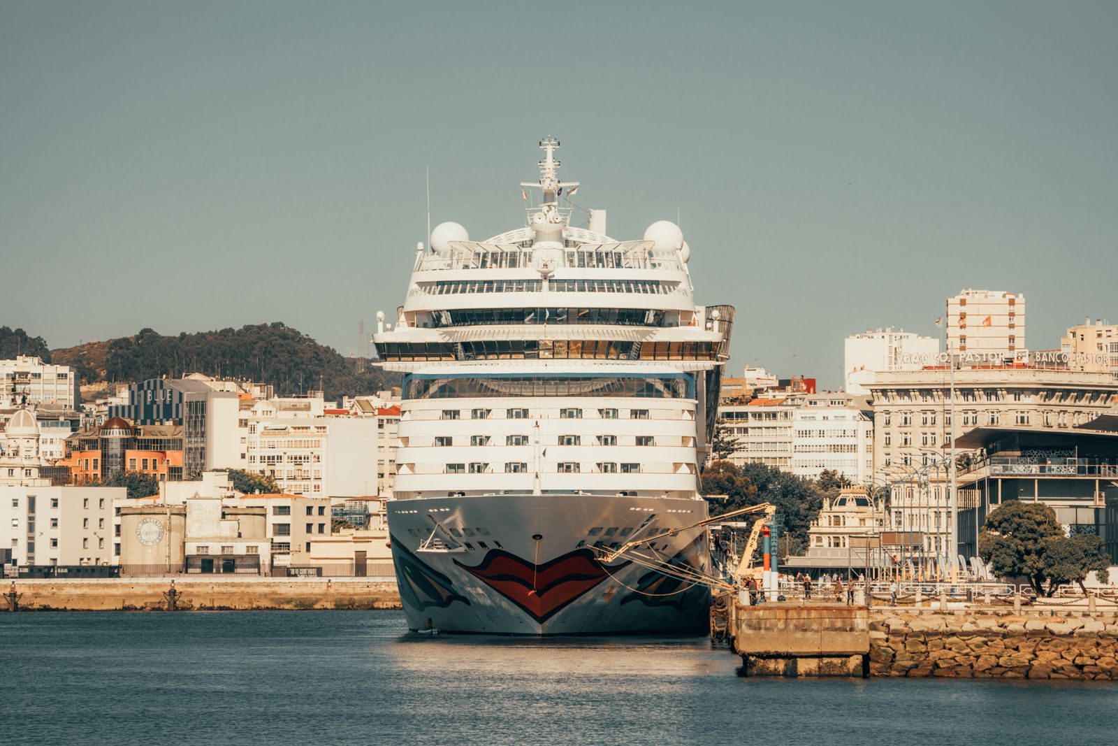 A large cruise ship docked in a city harbour, where port charges in cruise taxes and fees begin