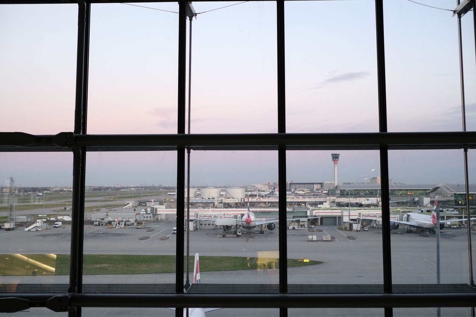 Airliners on the tarmac seen through an airport terminal window